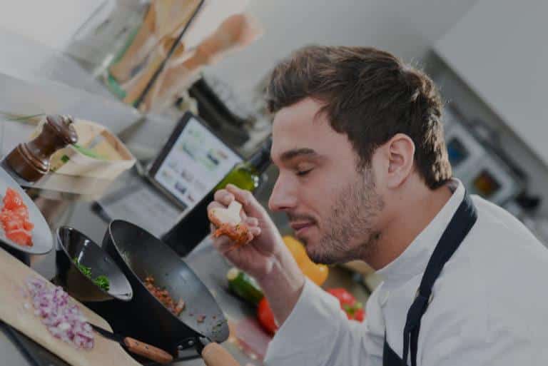 Homme en cuisine qui sent la nourriture dans une spatule