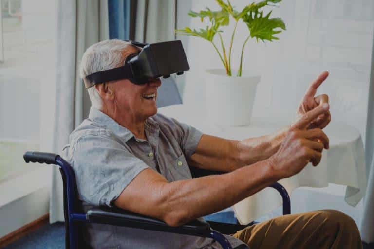 Homme âgé sur un fauteuil roulant qui s'amuse avec un casque de réalité virtuelle